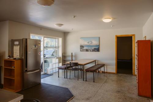 a kitchen and dining room with a table and a refrigerator at Hippo Lodge Backpackers in Queenstown