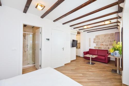 a living room with a red couch and a table at Heritage Vista in Dubrovnik