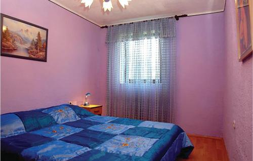 a bedroom with a blue bed and a window at Awesome Apartment In Medulin With Wifi in Medulin
