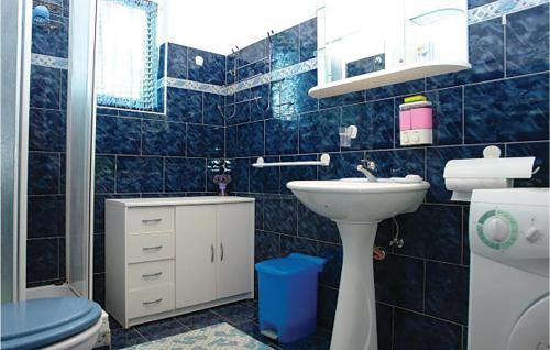 a blue tiled bathroom with a toilet and a sink at Awesome Apartment In Medulin With Wifi in Medulin