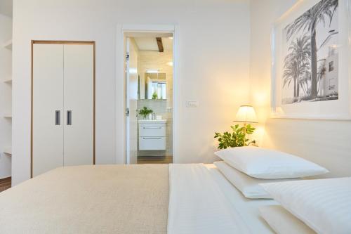 a white bedroom with a bed and a bathroom at Heritage Vista in Dubrovnik