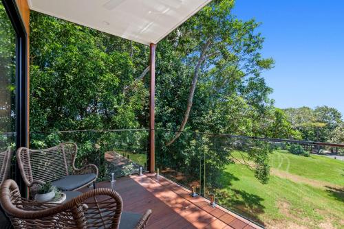 eine abgeschirmte Veranda mit Stühlen und einem Tisch auf einer Terrasse in der Unterkunft The Ridge at Maleny 1 Bedroom Villa in Maleny