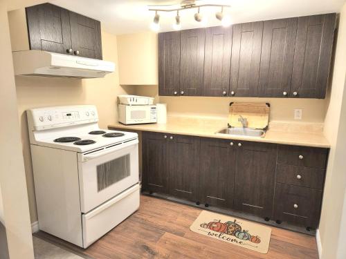 a kitchen with a white stove and a sink at Cozy spacious Apt In Laval, Greater Montreal in Laval