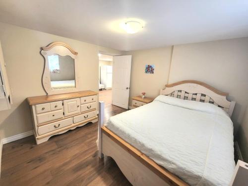 a bedroom with a bed and a dresser and a mirror at Cozy spacious Apt In Laval, Greater Montreal in Laval