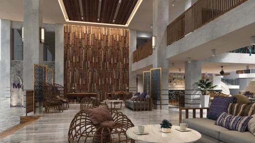 a lobby with couches and chairs and tables at Mercure Langkawi Pantai Cenang in Pantai Cenang
