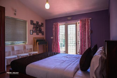 a bedroom with a large bed and a window at Pear Mount Farm House in Kodaikānāl
