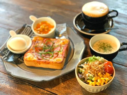 a table with a plate with toast and a salad and a cup of coffee at Sparky’s House in Naoshima