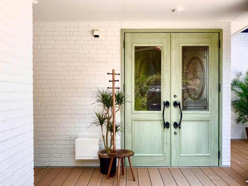 a green door on a house with a cross at Sparky’s House in Naoshima