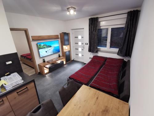 a living room with a bed and a flat screen tv at Apartma Auriga in Portorož