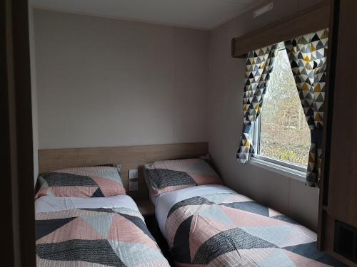 A bed or beds in a room at Little Heaven self-catering caravan in Church Farm Holiday Park
