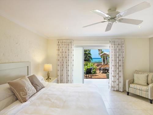 Schlafzimmer mit einem Bett und einem Deckenventilator in der Unterkunft Southwinds Villa is a three bedroom beach front property with a beautiful big in in Saint Peter