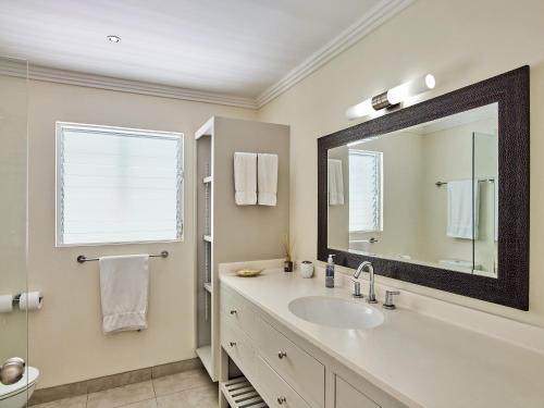 ein Bad mit einem Waschbecken und einem Spiegel in der Unterkunft Southwinds Villa is a three bedroom beach front property with a beautiful big in in Saint Peter