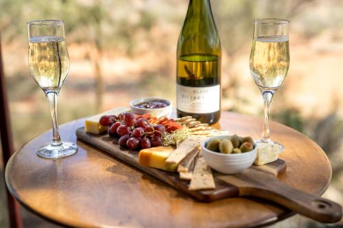 a table topped with a glass of wine and a plate of food at Kings Creek Station in Kings Canyon