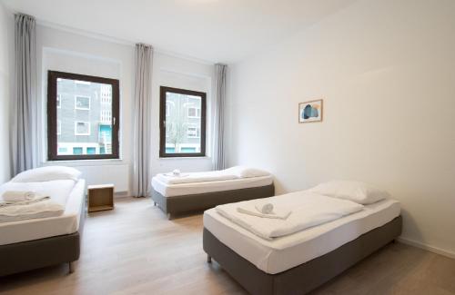 three beds in a room with two windows at Tolstov Apartments - 4 Room Apartments - 30 Min Messe DUS in Duisburg
