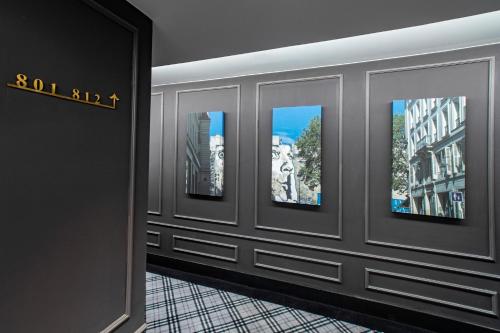 a room with four pictures on the wall at The Quartier Hotel Phromphong - Thonglor in Bangkok