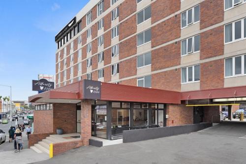 a store front of a brick building with people walking outside at Allurity Hotel in Hobart