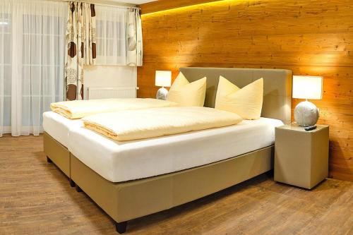 - une chambre avec un grand lit et un mur en bois dans l'établissement Apartment in Wildschönau with a balcony or terrace, à Niederau