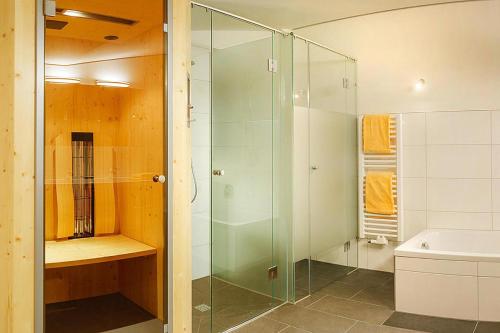 een badkamer met een glazen douche en een wastafel bij Apartment in Wildschönau with a balcony or terrace in Niederau