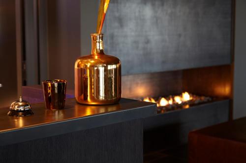 a gold bottle sitting on a table next to a fireplace at Alda Hotel Reykjavík in Reykjavík