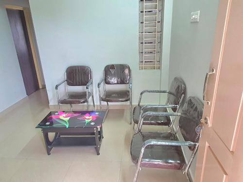 a room with chairs and a table and a table and chairs at Hallima Service Apartments Home Stay purpose Guest House 2 in Pudukkottai