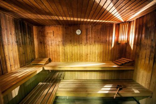 a wooden sauna with a clock on the wall at Laias Caldaria hotel y Balneario in Laias