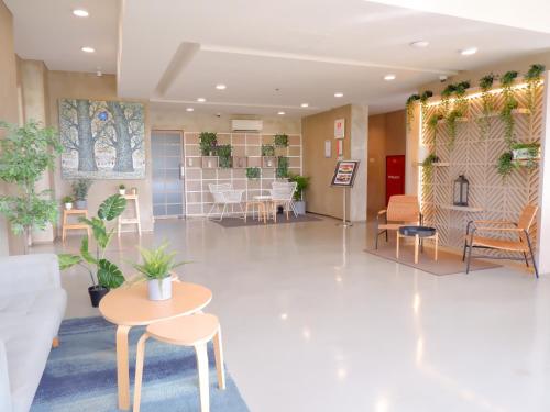 a lobby with a waiting area with tables and chairs at Swiss-Belexpress Cilegon in Cilegon