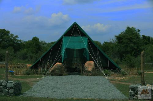 uma tenda de pirâmide verde com algumas pedras dentro em Basecamp - Yala em Yala