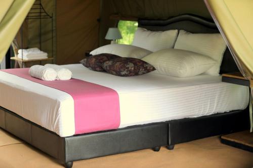 a large bed with two pillows on top of it at Basecamp - Yala in Yala