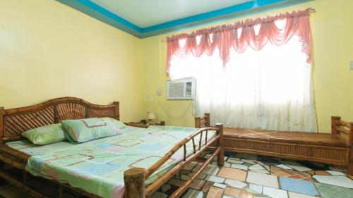 ein Schlafzimmer mit einem großen Bett und einem Fenster in der Unterkunft RGV Beach Resort Batangas in Calatagan