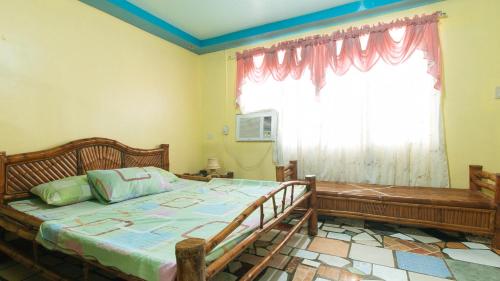 a bedroom with a large bed and a window at RGV Beach Resort Batangas RedPartner in Calatagan