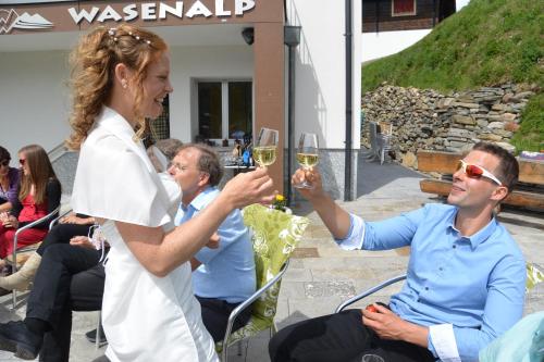 a woman and man holding glasses of wine at Berggasthaus Wasenalp in Brig