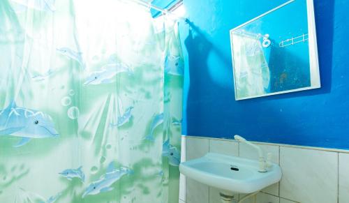 a blue bathroom with a sink and a shower curtain at RGV Beach Resort Batangas RedPartner in Calatagan