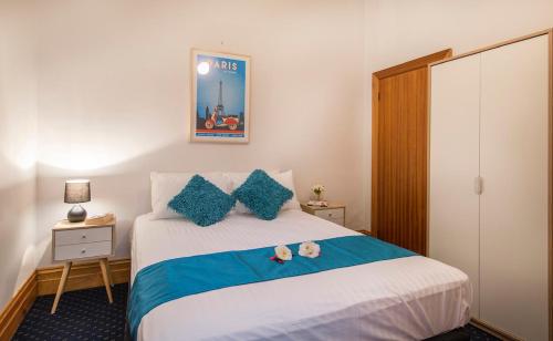 a bedroom with a bed with two stuffed animals on it at Charm on Carrington in Adelaide