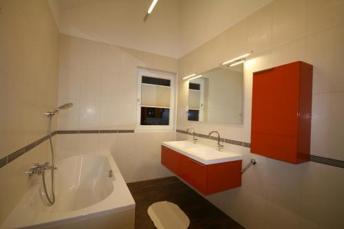 a bathroom with a white tub and a sink and a tub at Appartements Zur Kapelle in Kaprun