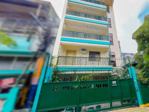 un edificio con una puerta verde con plantas. en OYO 840 Orangenest Apartelle, en Manila