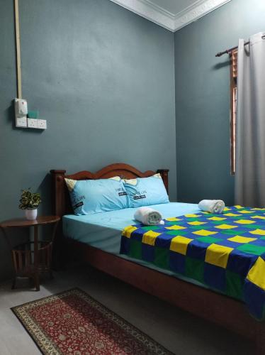 a bedroom with a bed with a colorful blanket at Kubang Kerian DECO HOMESTAY Aircond Wifi Netflix in Kota Bharu