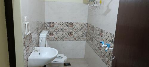 Un baño con un inodoro blanco y un lavabo. en Bhargava Ashram, en Vrindāvan