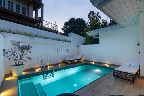 a swimming pool with lights in a backyard at night at Ru Boutique in Kandy
