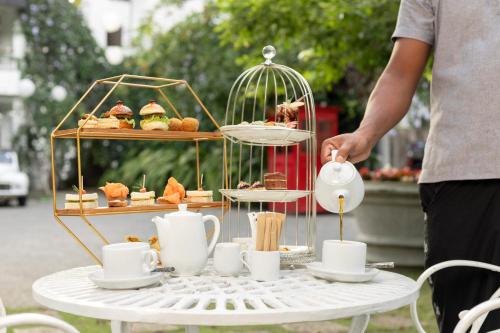 a man standing next to a table with a tray of pastries at Ru Boutique in Kandy