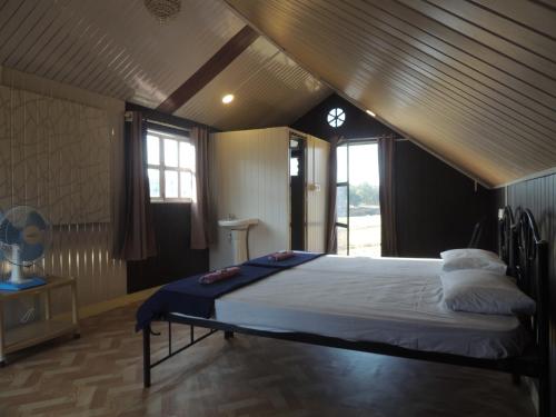 - une chambre mansardée avec un grand lit dans l'établissement Room in Farmhouse - Dandeli - Aura Jungle Stay, à Ganeshgudi