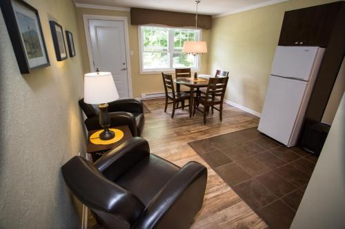 a living room with chairs and a table and a refrigerator at Studiotel Bromont in Bromont