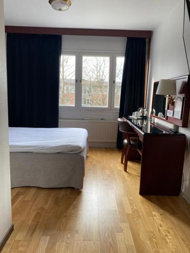 a bedroom with a bed and a desk and a window at Place Lund in Lund