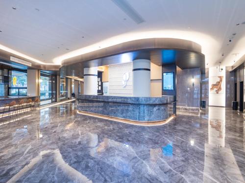 a lobby with a marble floor and a reception counter at Country Inn&Suites by Radisson, Shanghai PVG in Shanghai