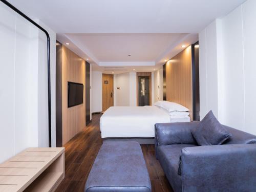 a hotel room with a bed and a couch at Country Inn&Suites by Radisson, Shanghai PVG in Shanghai