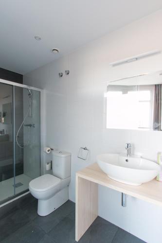 a white bathroom with a sink and a toilet at Bilbao City Rooms in Bilbao