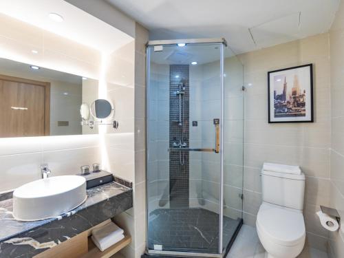 Country Inn&Suites by Radisson, Shanghai PVG في شانغهاي: حمام مع دش ومرحاض ومغسلة