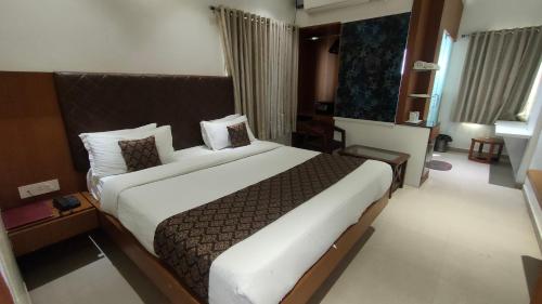 a bedroom with a large bed in a hotel room at Hotel Vintage in Vadodara