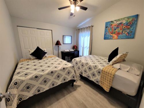 um quarto com 2 camas e uma ventoinha de tecto em Beautiful townhouse easy access to everything. em Clearwater