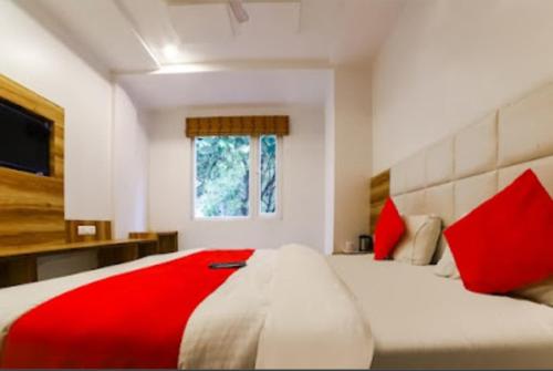 een slaapkamer met een groot bed met rode kussens bij Hotel Awesome International in New Delhi