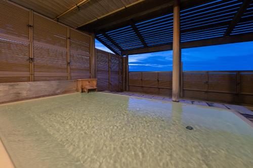 una grande piscina d'acqua in una grande stanza con di Kaiyutei a Kawazu